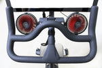 Two black fans with red blades attached to mounting bracket installed on a Peloton bike